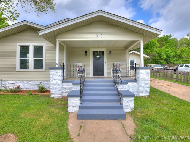 view of front of house with a porch, fence, and a front lawn