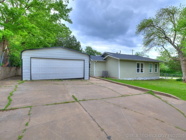 view of front of house featuring a garage, fence, central AC unit, and a front lawn