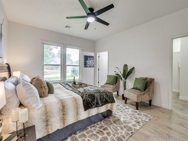 bedroom with visible vents, a ceiling fan, baseboards, and light wood-type flooring