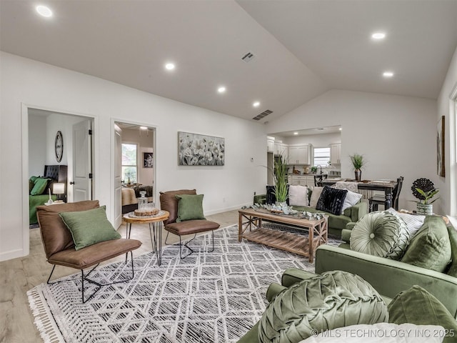living room featuring recessed lighting, visible vents, and lofted ceiling