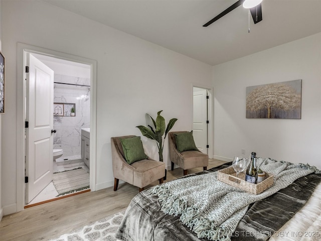 bedroom featuring ceiling fan, baseboards, ensuite bathroom, and wood finished floors