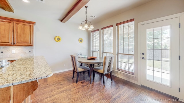 dining room with visible vents, wood finished floors, baseboards, beamed ceiling, and a chandelier
