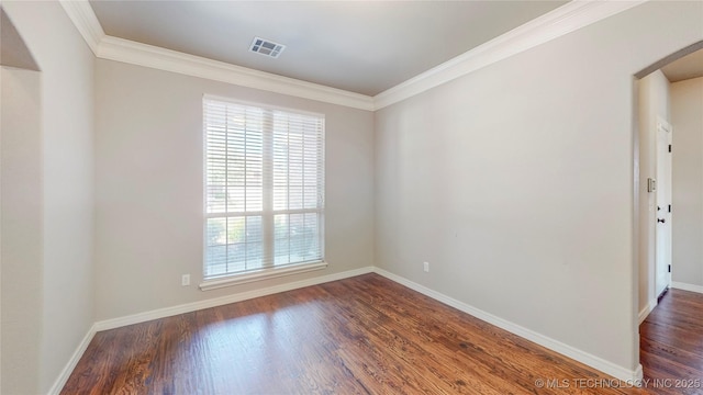 empty room featuring crown molding, arched walkways, visible vents, and dark wood-style floors
