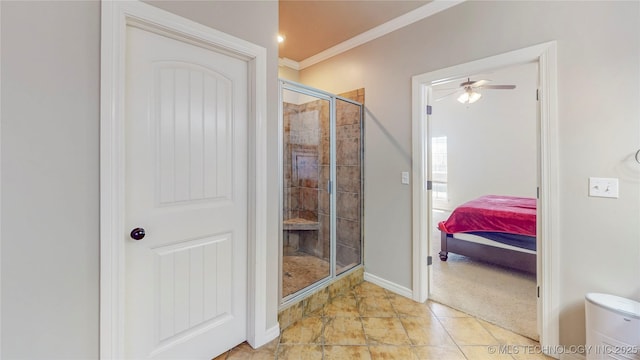ensuite bathroom featuring crown molding, baseboards, ceiling fan, a shower stall, and ensuite bath