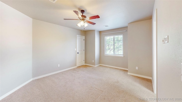 empty room with a ceiling fan, baseboards, visible vents, and carpet