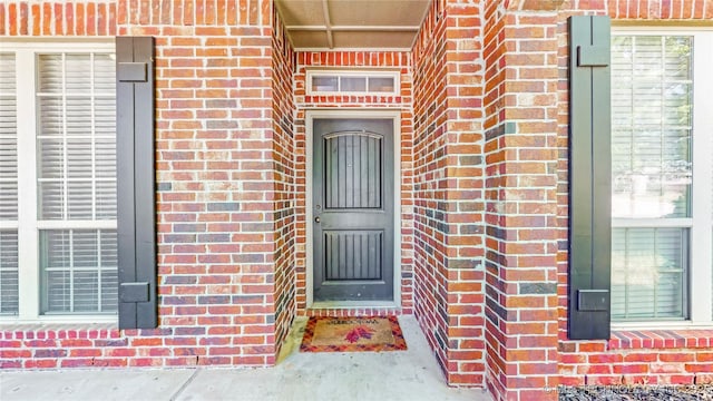 property entrance featuring brick siding