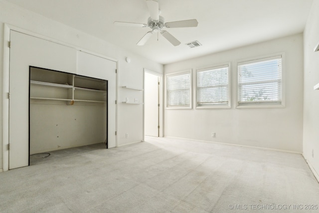 unfurnished bedroom with ceiling fan, carpet, a closet, and visible vents