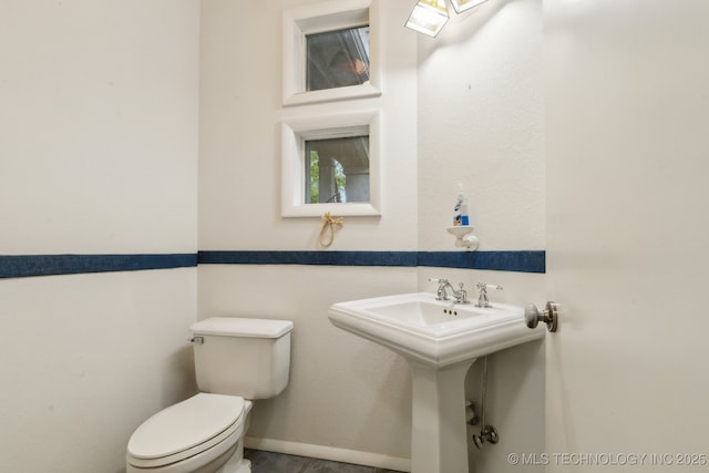 half bathroom with toilet and a sink