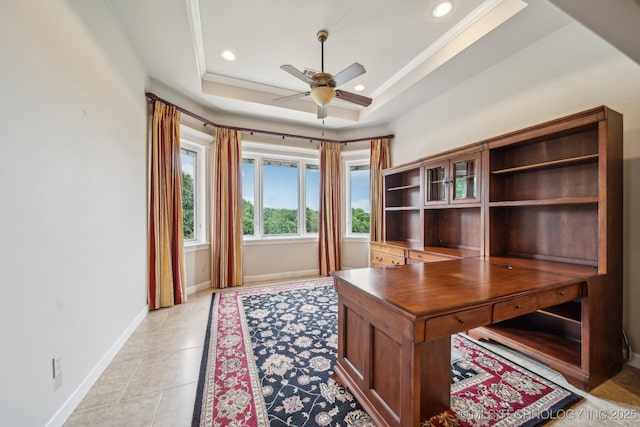 office area featuring a ceiling fan, light tile patterned floors, baseboards, ornamental molding, and a tray ceiling