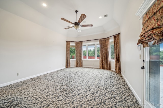 empty room featuring a high ceiling, carpet, a ceiling fan, baseboards, and visible vents