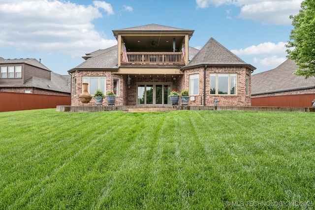 rear view of house featuring a yard, brick siding, and a balcony