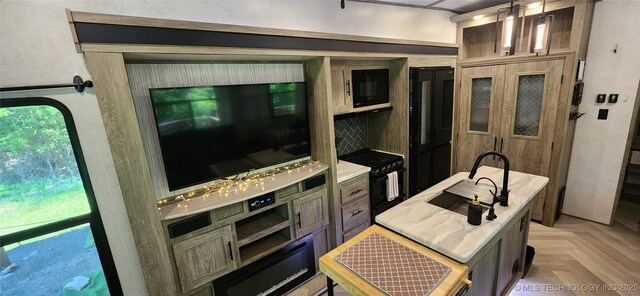 kitchen with light countertops, hanging light fixtures, a sink, and black appliances