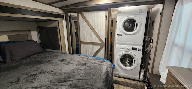 washroom with carpet, stacked washer / drying machine, and laundry area