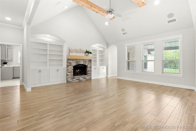 15916 E 106th Pl, Owasso, OK 74055 - unfurnished living room with baseboards, ceiling fan, visible vents, built in shelves, and high vaulted ceiling