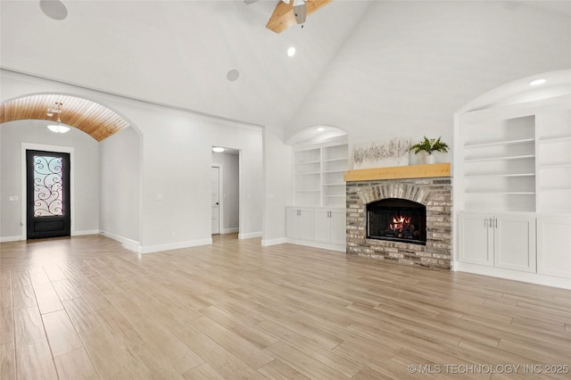 15916 E 106th Pl, Owasso, OK 74055 - unfurnished living room with a ceiling fan, a brick fireplace, built in features, baseboards, and light wood-style floors