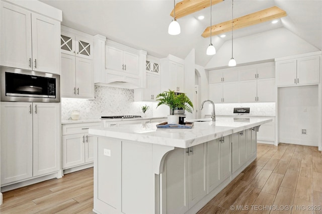 15916 E 106th Pl, Owasso, OK 74055 - kitchen featuring white cabinetry, built in microwave, a sink, and cooktop