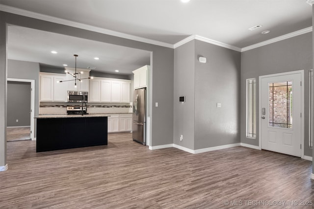 543 Edgewood, Durant, OK 74701 - kitchen featuring appliances with stainless steel finishes, wood finished floors, backsplash, white cabinets, and baseboards