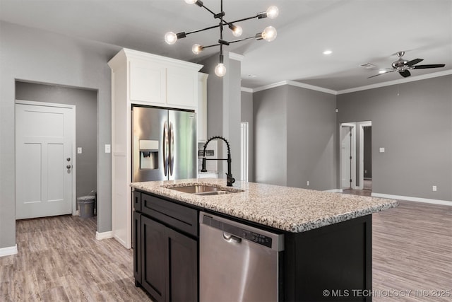 543 Edgewood, Durant, OK 74701 - kitchen with appliances with stainless steel finishes, a sink, ornamental molding, light wood-style floors, and an island with sink