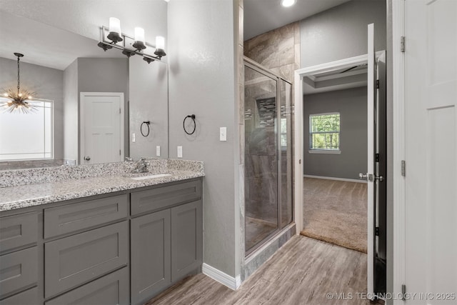 543 Edgewood, Durant, OK 74701 - bathroom with a chandelier, a shower stall, wood finished floors, vanity, and baseboards