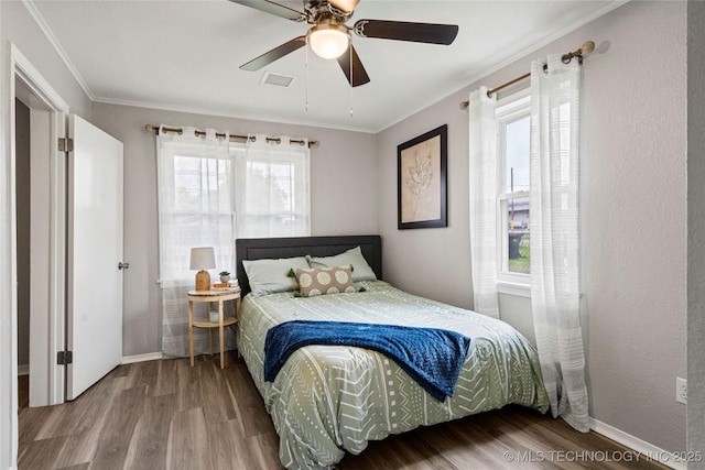 bedroom featuring crown molding, baseboards, and wood finished floors