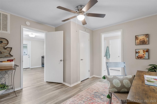 interior space featuring crown molding, visible vents, baseboards, ceiling fan, and light wood-style flooring
