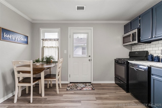 kitchen with visible vents, decorative backsplash, light wood finished floors, black appliances, and blue cabinetry