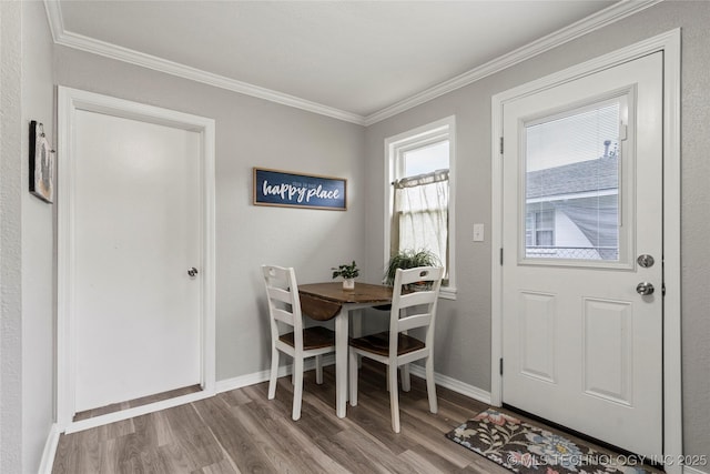 entryway with baseboards, ornamental molding, and wood finished floors