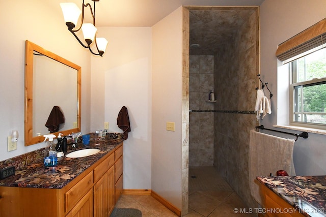 bathroom featuring vanity, baseboards, tile patterned floors, a chandelier, and a tile shower