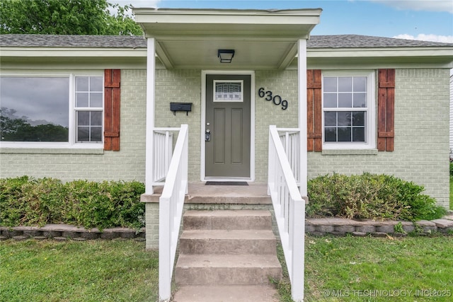 view of exterior entry featuring brick siding