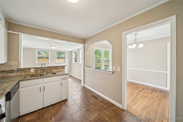 kitchen with visible vents, dishwasher, a sink, baseboards, and white cabinetry