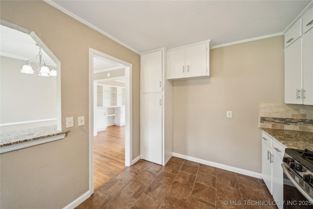 kitchen featuring white cabinets, a chandelier, decorative backsplash, and stainless steel range with gas cooktop