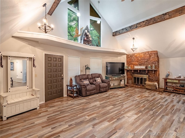 living room with an inviting chandelier, wood finished floors, and high vaulted ceiling