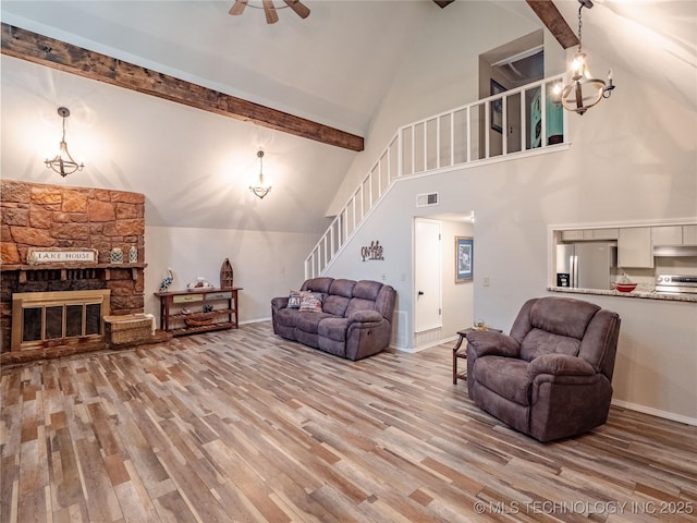 living area with visible vents, wood finished floors, and stairway