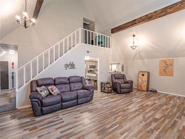 living area with high vaulted ceiling, beam ceiling, stairs, and wood finished floors
