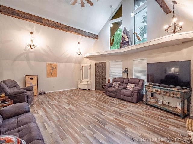 living area with wood finished floors, beamed ceiling, baseboards, high vaulted ceiling, and ceiling fan with notable chandelier