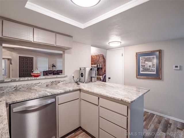 kitchen with baseboards, a peninsula, wood finished floors, and dishwasher