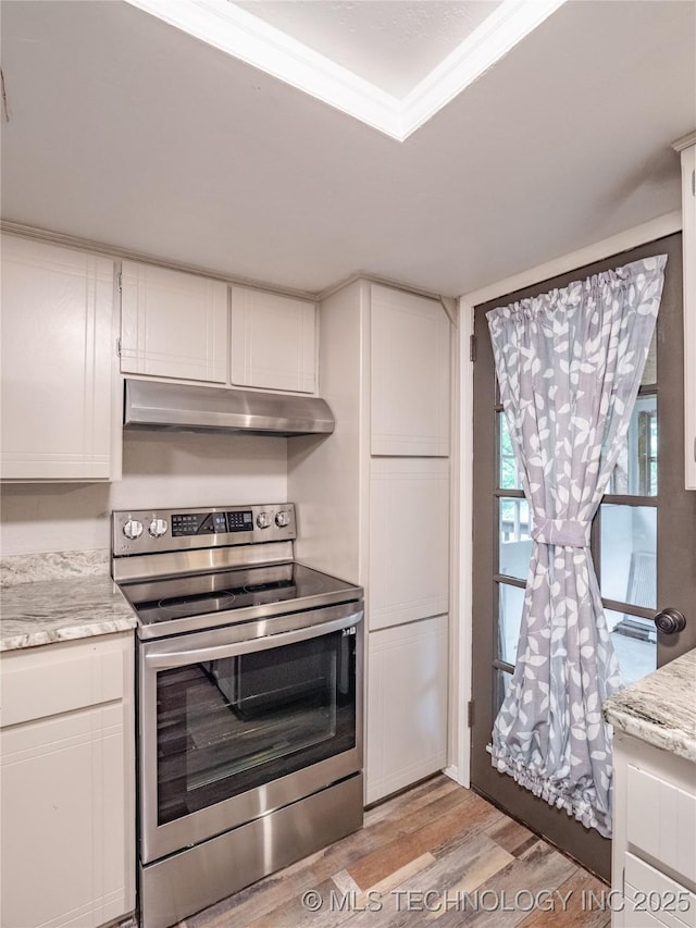 kitchen with light wood-style floors, white cabinets, under cabinet range hood, and stainless steel electric stove