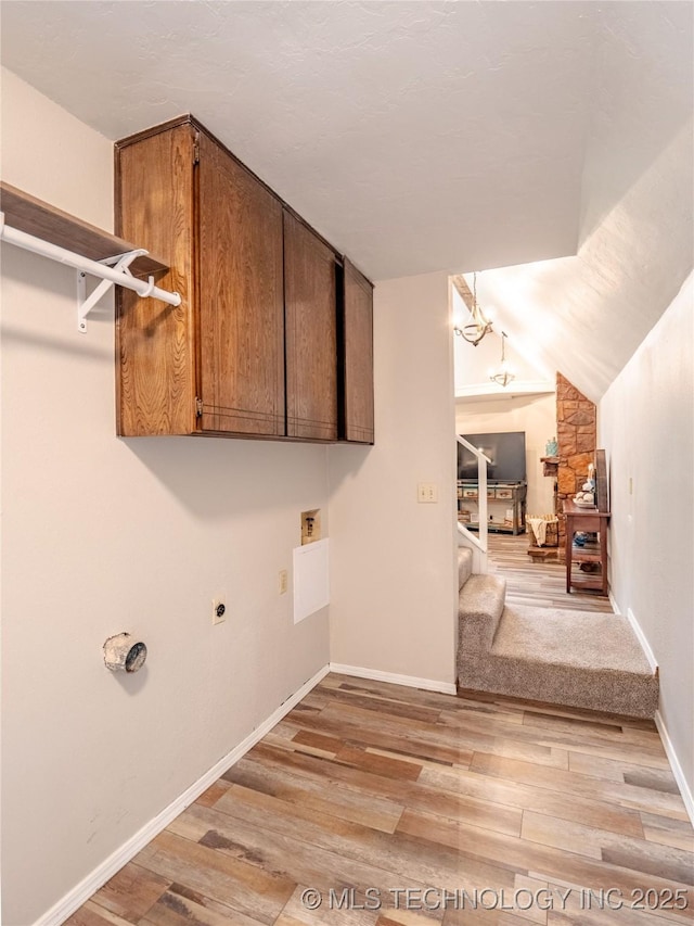 laundry area featuring washer hookup, hookup for an electric dryer, cabinet space, baseboards, and light wood-style flooring