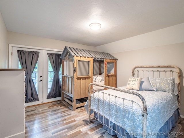 bedroom featuring wood finished floors and access to exterior