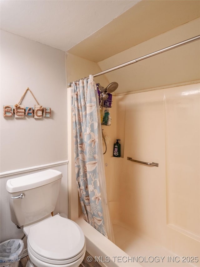 bathroom with a shower with curtain and toilet