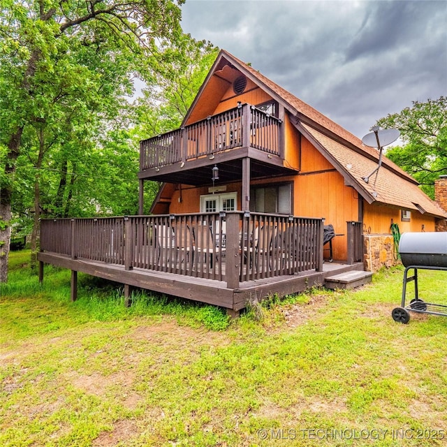 back of house featuring a yard, a wooden deck, and french doors