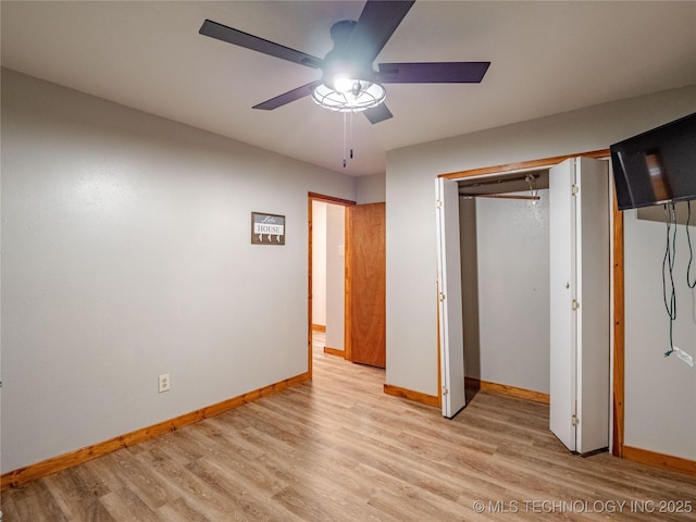 unfurnished bedroom featuring baseboards, a ceiling fan, and light wood-style flooring