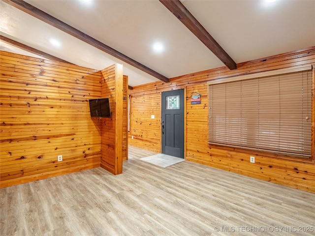 unfurnished living room with recessed lighting, lofted ceiling with beams, wood walls, and wood finished floors
