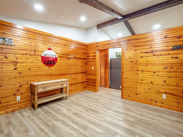 empty room featuring recessed lighting, wood walls, light wood finished floors, and lofted ceiling with beams