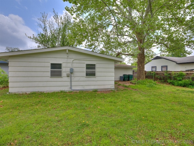 back of property featuring a yard and fence