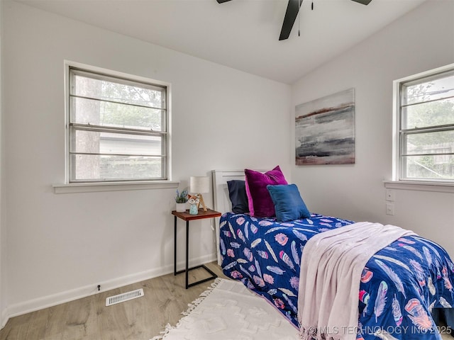 bedroom featuring a ceiling fan, baseboards, visible vents, and wood finished floors