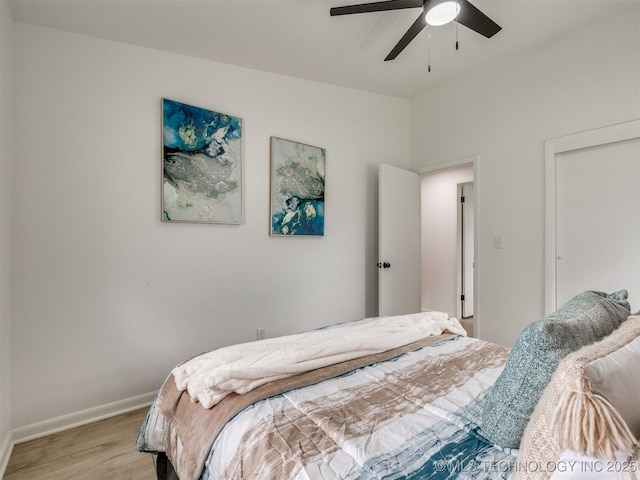 bedroom with baseboards, ceiling fan, and light wood-style floors