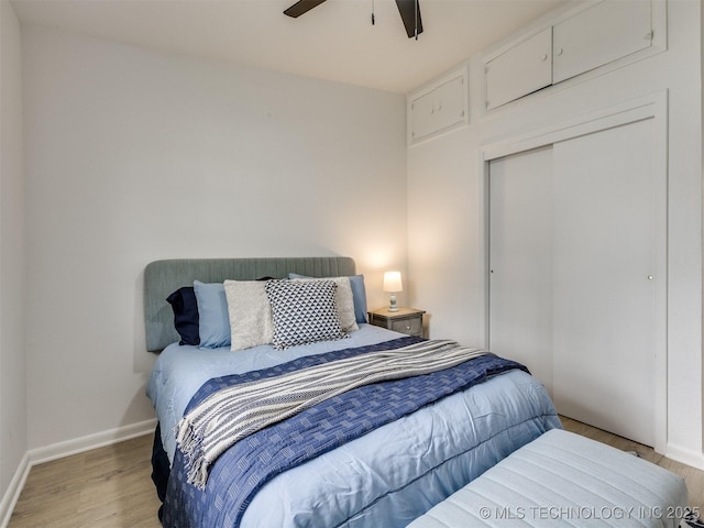 bedroom featuring baseboards, a ceiling fan, a closet, and light wood-type flooring