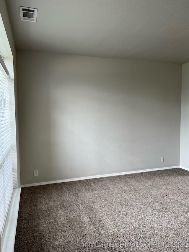 empty room featuring baseboards, visible vents, and carpet