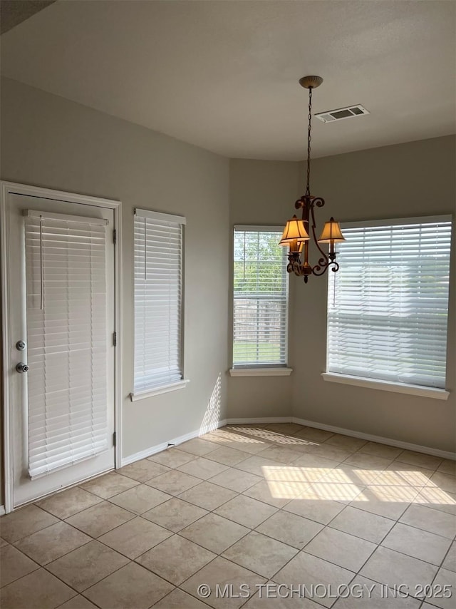 unfurnished dining area with an inviting chandelier, baseboards, light tile patterned flooring, and visible vents